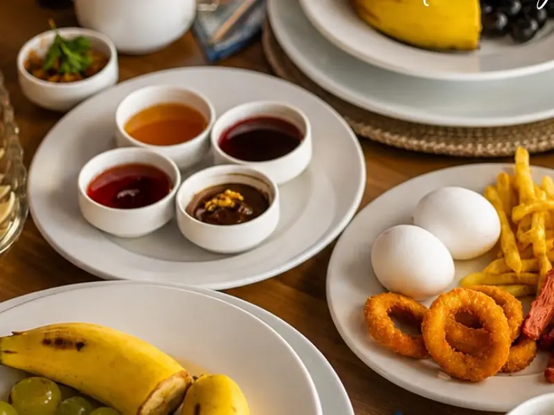Der Frühstückstisch: Käseplatte, Marmeladen, gekochte Eier, Gebratenes und Obst